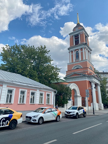 Moscow, Russia - July 25, 2021: Church of the Life-Giving Trinity in Vishnyaki.  Three different car sharing vehicles parked on street.