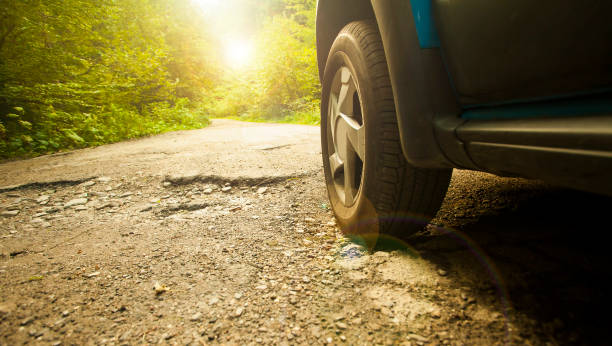 car tire and cracked damaged road stock photo