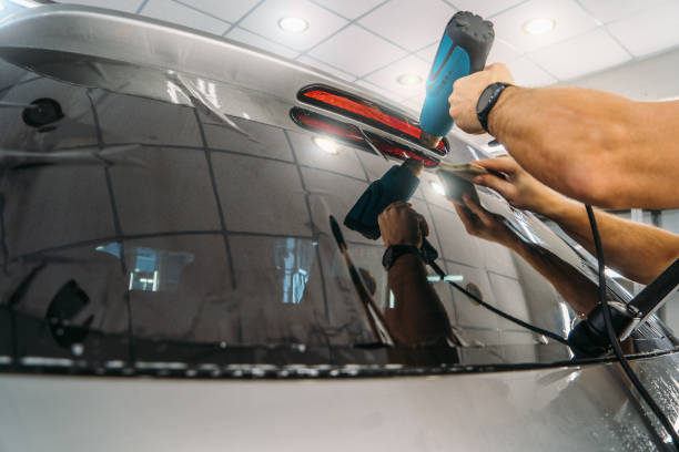 Car window tinting. Process of Installation window tint in Car Detailing Studio Garage by professional detailer stock photo