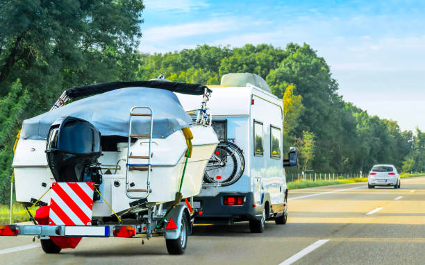 Caravan and trailer for motor boats on road in Switzerland Vacation trip with Caravan Car and trailer with motorcycles on road of Switzerland. Camper and Summer drive on highway. Holiday journey in rv motorhome for recreation. Motor home motion ride. electric motor photos stock pictures, royalty-free photos & images