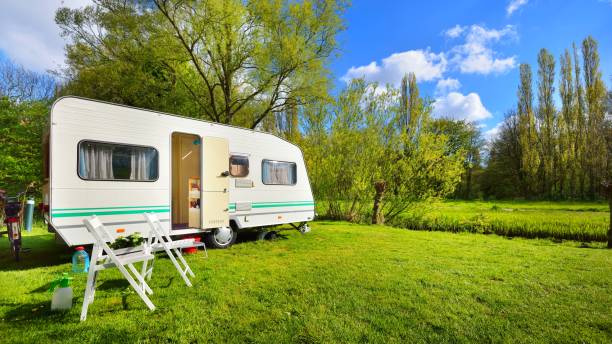 Caravan trailer on a green lawn, on a sunny spring day stock photo