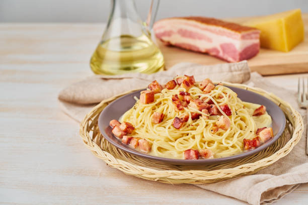 Carbonara pasta. Spaghetti with pancetta, egg, parmesan cheese and cream sauce. Side view, copy space. Traditional italian cuisine. stock photo
