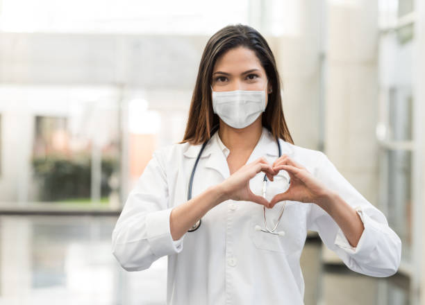 cardiologista que trabalha no hospital durante a pandemia covid-19 usando uma máscara facial - cardiologista - fotografias e filmes do acervo