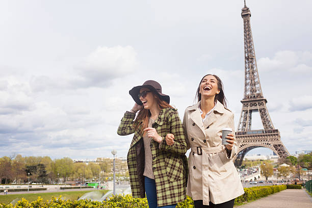 Carefree young women holding hands and having fun in Paris stock photo