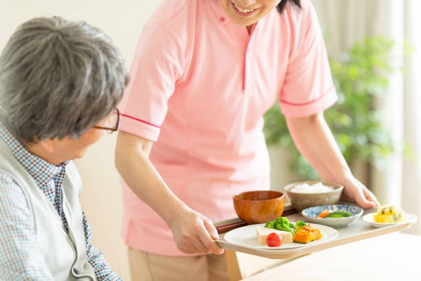 Caregiver preparing a meal Person assisted living stock pictures, royalty-free photos & images