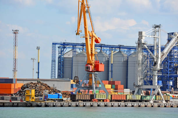 Cargo crane and grain silo stock photo