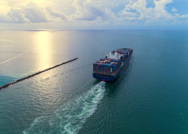cargo ship leaving port - aerial container ship imagens e fotografias de stock