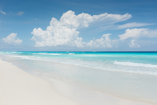 Beautiful turquoise caribbean water with gentle waves and white sandy beach on a beautiful sunny day in Mexico.. Cancun, Mexico, Central America.