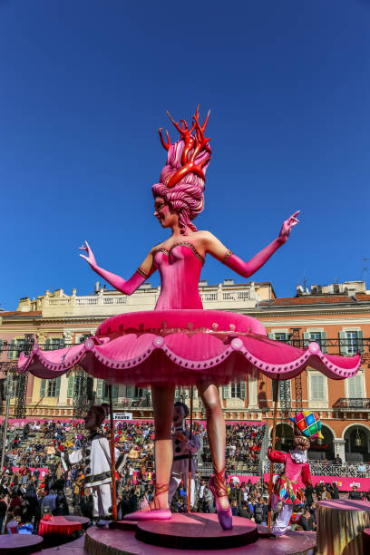 Carnaval de Nice, This years theme King of Cinema (ROI du Cinéma)  - Close up of pink ballerina in amoungst the stands of people with clown assistants below her tutu stock photo
