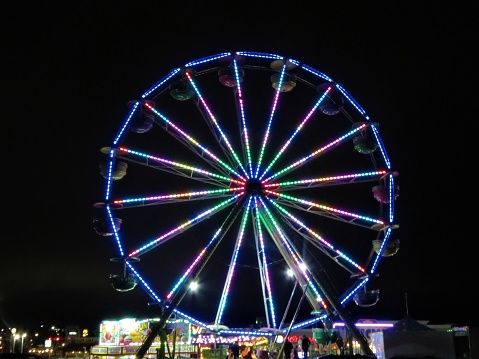 Stephenville, Texas, USA – September, 10, 2020: A Ferris Wheel lights up at night when a traveling carnival comes to town.