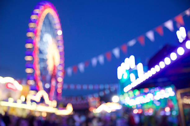 Carnival Scene Here you can see a defocused carnival scene with a ferris wheel in the backround amusement park ride stock pictures, royalty-free photos & images