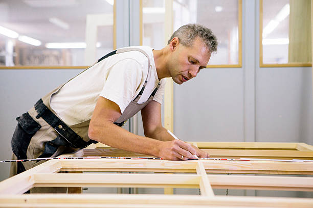 Carpenter working at a window frame stock photo