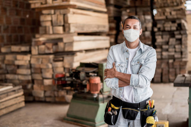 코로나바이러스를 피하기 위해 얼굴 마스크를 쓰고 작업장에서 일하는 목수 - construction worker 뉴스 사진 이미지