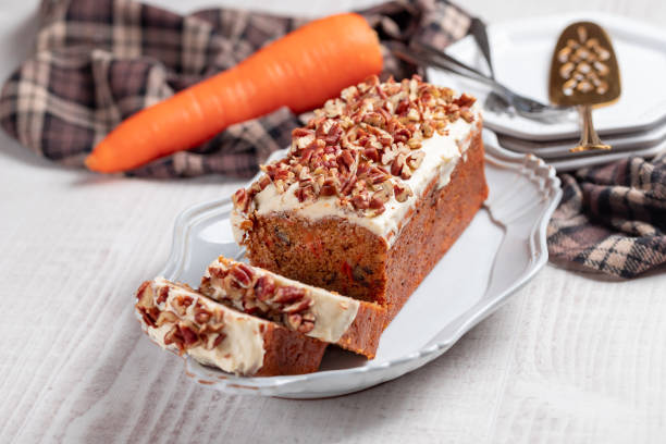 Carrot cake with cream cheese Icing on a rustic white wooden background stock photo