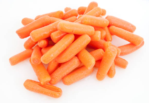 Carrots Mound of baby carrots on a white background. peeled stock pictures, royalty-free photos & images