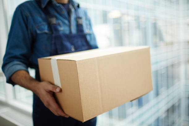 Carrying package Relocation service worker or courier carrying packed carton box while distributing it to receiver post structure stock pictures, royalty-free photos & images