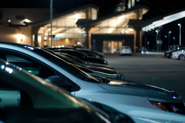 cars in parking lot at night row of various vehicles parked at night with dim illumination car rental stock pictures, royalty-free photos & images