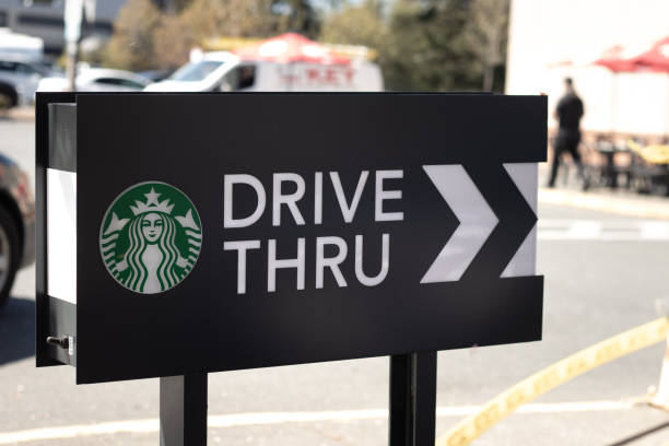 Cars lining up to order food using drive-thru facilitiy at local Starbucks Coffee Shop Courtenay,Canada - April 22,2021: Cars lining up to order food using drive-thru facilitiy at local Starbucks Coffee Shop drive thru queue stock pictures, royalty-free photos & images