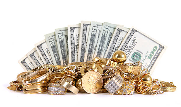 Cash for Gold Fanned rows of money behind a stack of scrap gold. gold jewelry stock pictures, royalty-free photos & images