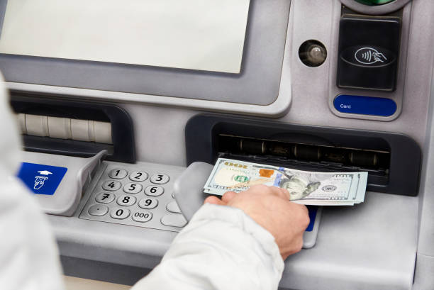 Cash withdrawal in dollars from an ATM.  bank deposit slip stock pictures, royalty-free photos & images