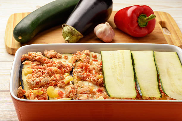 Casserole with chicken, eggplant, zucchini and tomatoes. Cooking process. stock photo