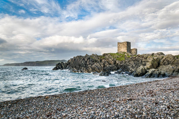 A Castle Looking Out to Sea This is an Irish castle on Dough Island, Donegal, Ireland.  The castle is purched on rocks that jut out into the sea. in the forground is a stone beach. county donegal stock pictures, royalty-free photos & images