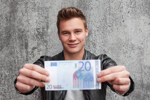 Casual young guy holding 20 euro note stock photo