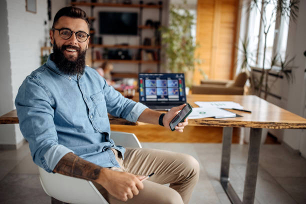 Casually clothed business man posing from his home office setup stock photo