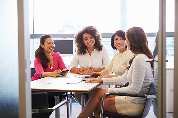 Casually dressed female colleagues talking in a meeting room Casually dressed female colleagues talking in a meeting room only women stock pictures, royalty-free photos & images