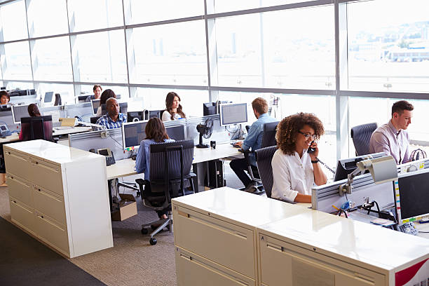 Casually dressed workers in a busy open plan office Casually dressed workers in a busy open plan office busy office stock pictures, royalty-free photos & images