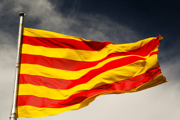 Catalan flag BARCELONA, circa 2015 - A close-up shot of a large sunlit Catalan flag against a dark sky catalonia stock pictures, royalty-free photos & images