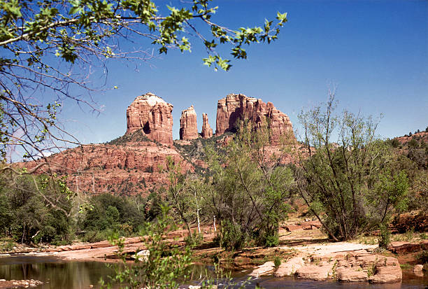 Cathedral Rock across the river Arizona's majestic Cathedral Rock, with water and foliage in the foreground. hearkencreative stock pictures, royalty-free photos & images