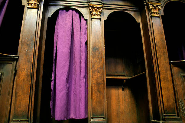 A Catholic confession booth with a purple curtain stock photo