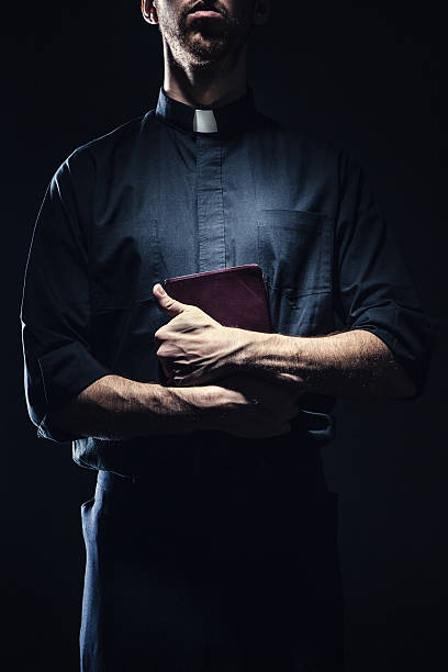 catholic priest holding a bible - prästkrage bildbanksfoton och bilder