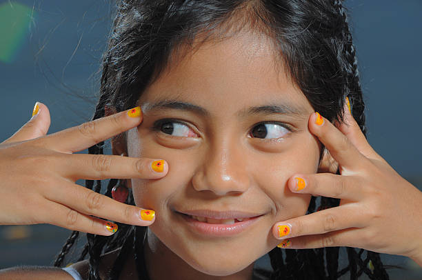Cats Eyes Young Asian girl smiles with fingers moving away from her face painting fingernails stock pictures, royalty-free photos & images