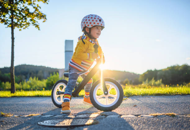 Caucasian Boy Driving Balance Bike Outdoors Caucasian boy with sports helmets driving balance bike outdoors on a sunny day. He is learning new skill. 2 3 years stock pictures, royalty-free photos & images
