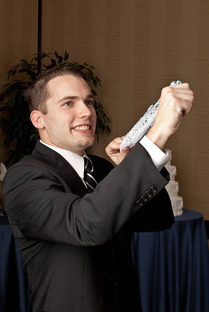 Caucasian groom flipping a garter belt stock photo
