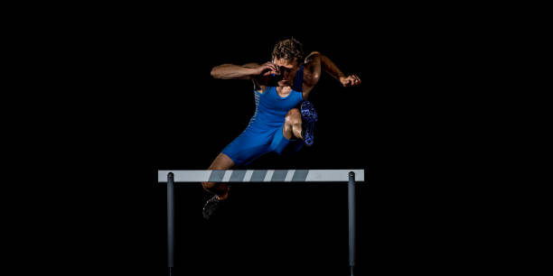 Caucasian hurdler in mid-air during a jump stock photo