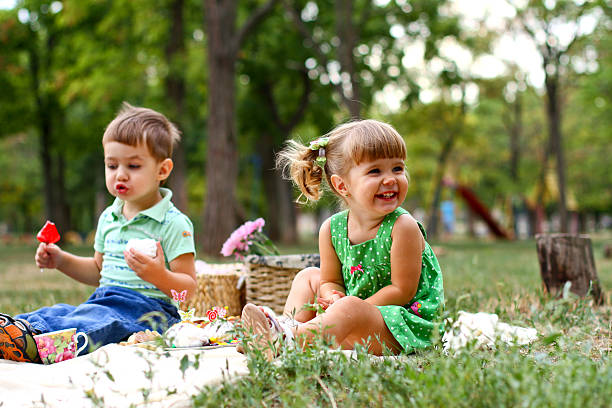 Caucasian little boy and girl eating sweets stock photo