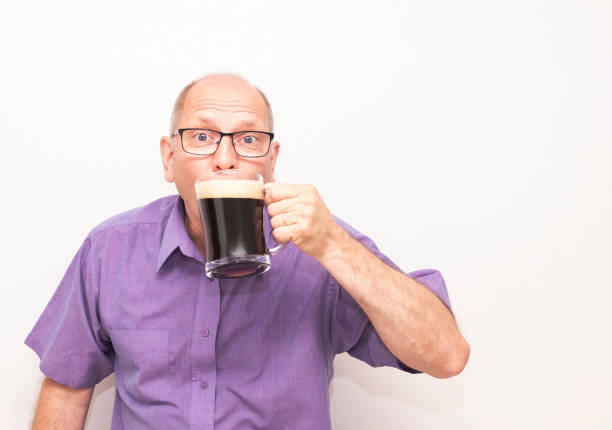 um homem caucasiano bebe cerveja com prazer e olha para a câmera. - social media - fotografias e filmes do acervo