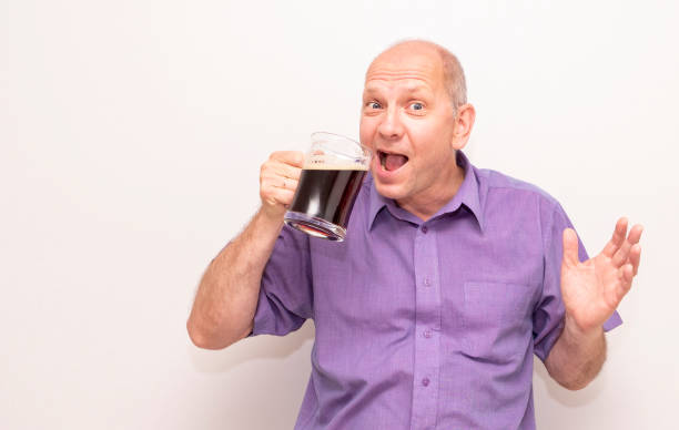 um homem caucasiano bebe cerveja com prazer e mostra com um gesto de mão, eu gosto de cerveja. - social media - fotografias e filmes do acervo