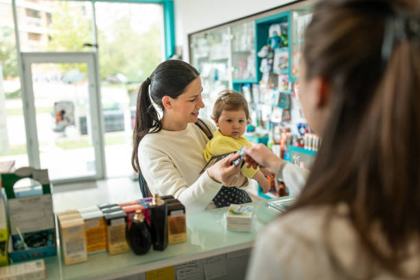 Caucasian mom talks with pharmacist stock photo