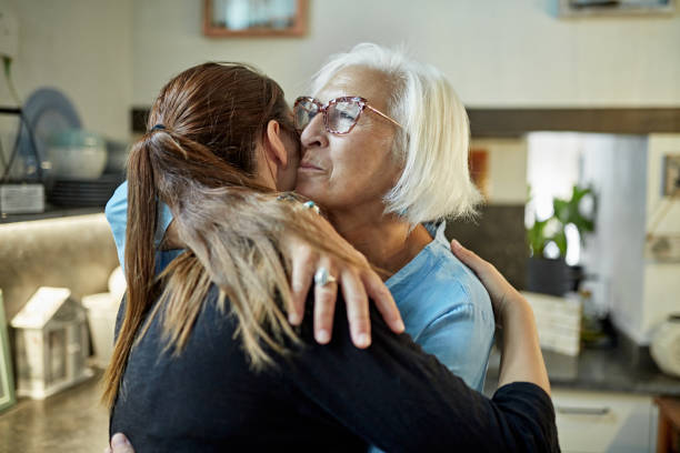 kaukasische moeder en volwassen dochter die het omhelzen - emotionele ondersteuning stockfoto's en -beelden