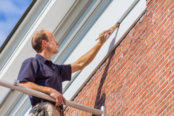 Caucasian painter painting  roof molding with brush stock photo