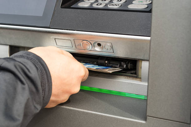 Caucasian person hand receiving banknotes from ATM machine. Outdoor cash withdrawal on a day. Bulgarian lev issuing by ATM on a man hand. Using Bank Atm. Selective focus. stock photo