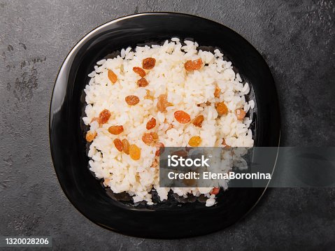 istock caucasian sweet pilaf with raisins on a black plate top view, rice with dried fruits 1320028206