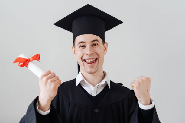 Caucasian young man feeling very excited to receive his bachelors degree Education, graduation and people concept - happy male student with diploma at home showing his emotions bachelor’s degrees online stock pictures, royalty-free photos & images