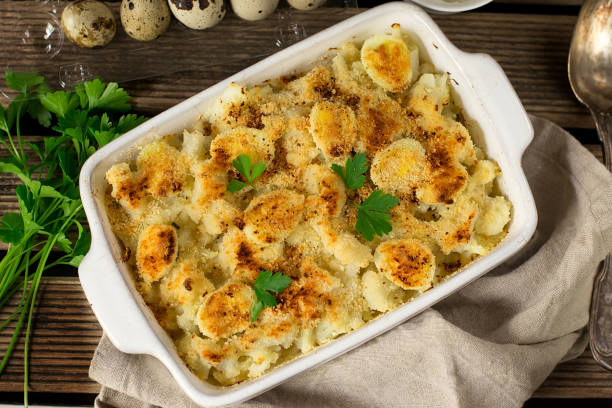 Cauliflower gratin with quail eggs baked with breadcrumbs Cauliflower gratin with quail eggs and parsley baked with breadcrumbs gratin stock pictures, royalty-free photos & images