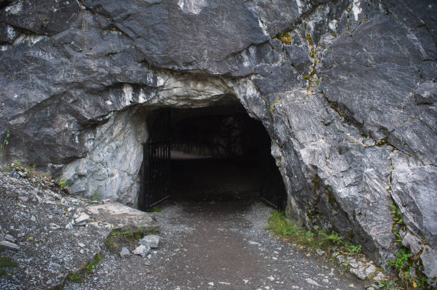 cave Entrance to dark cave in the rock cave stock pictures, royalty-free photos & images
