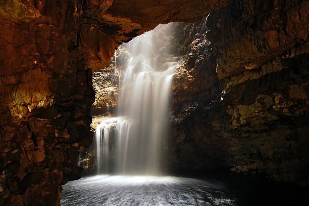 Cave Waterfall A waterfall and underground river running through a cave caithness stock pictures, royalty-free photos & images